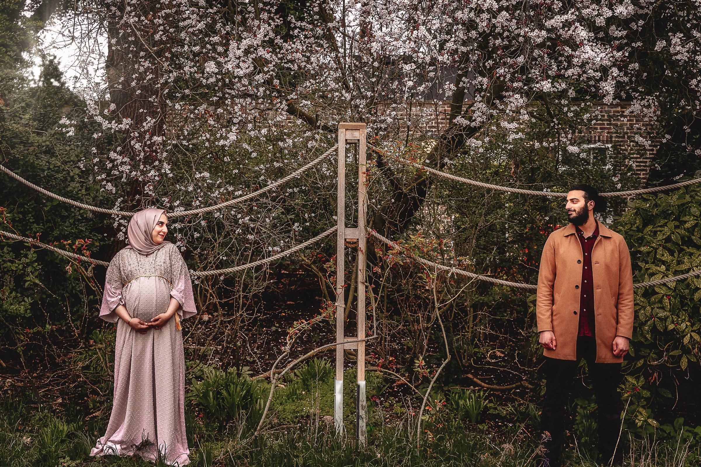 A pregnant woman framed by branches in the park