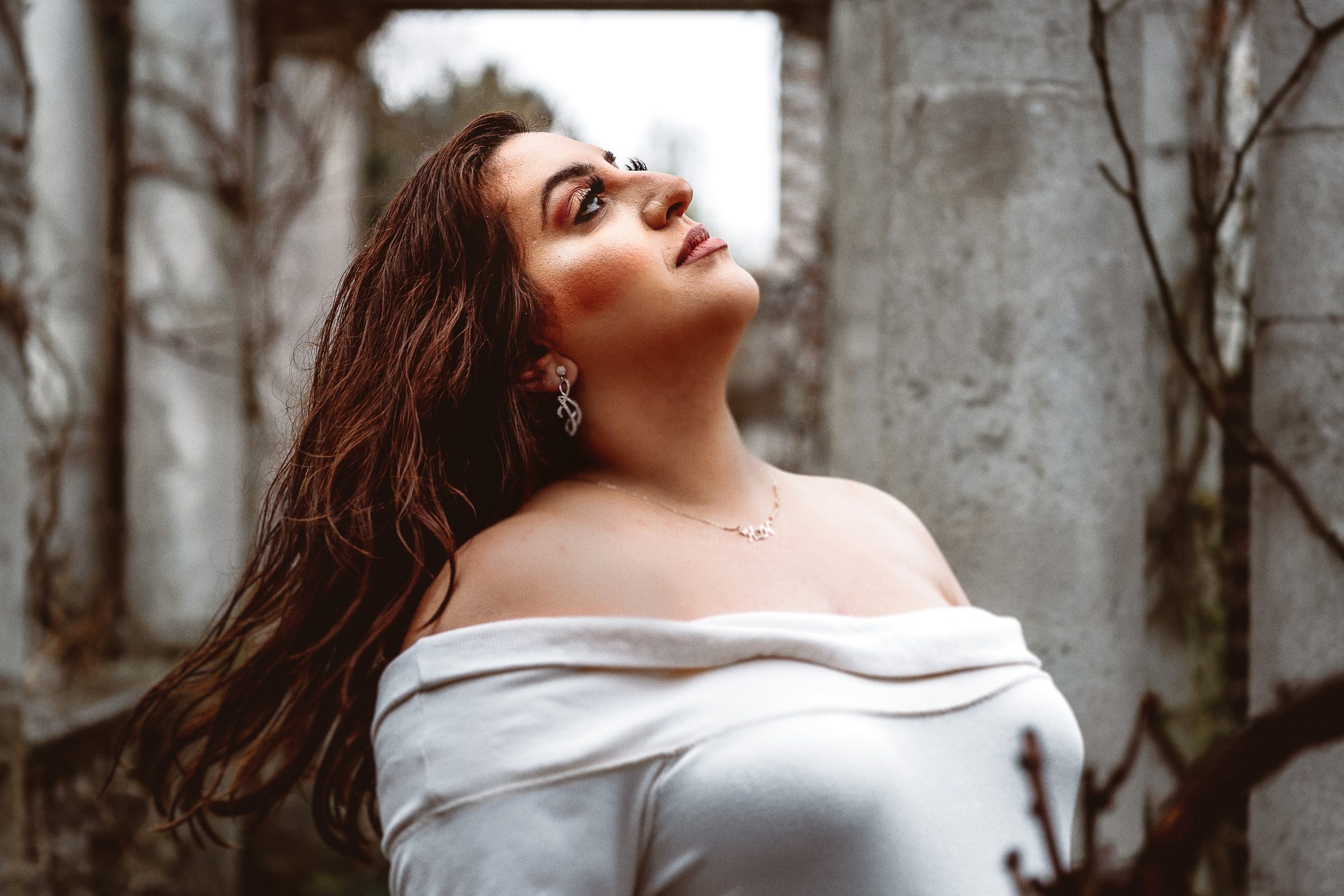 Noor lifting her face in a luminous maternity portrait
