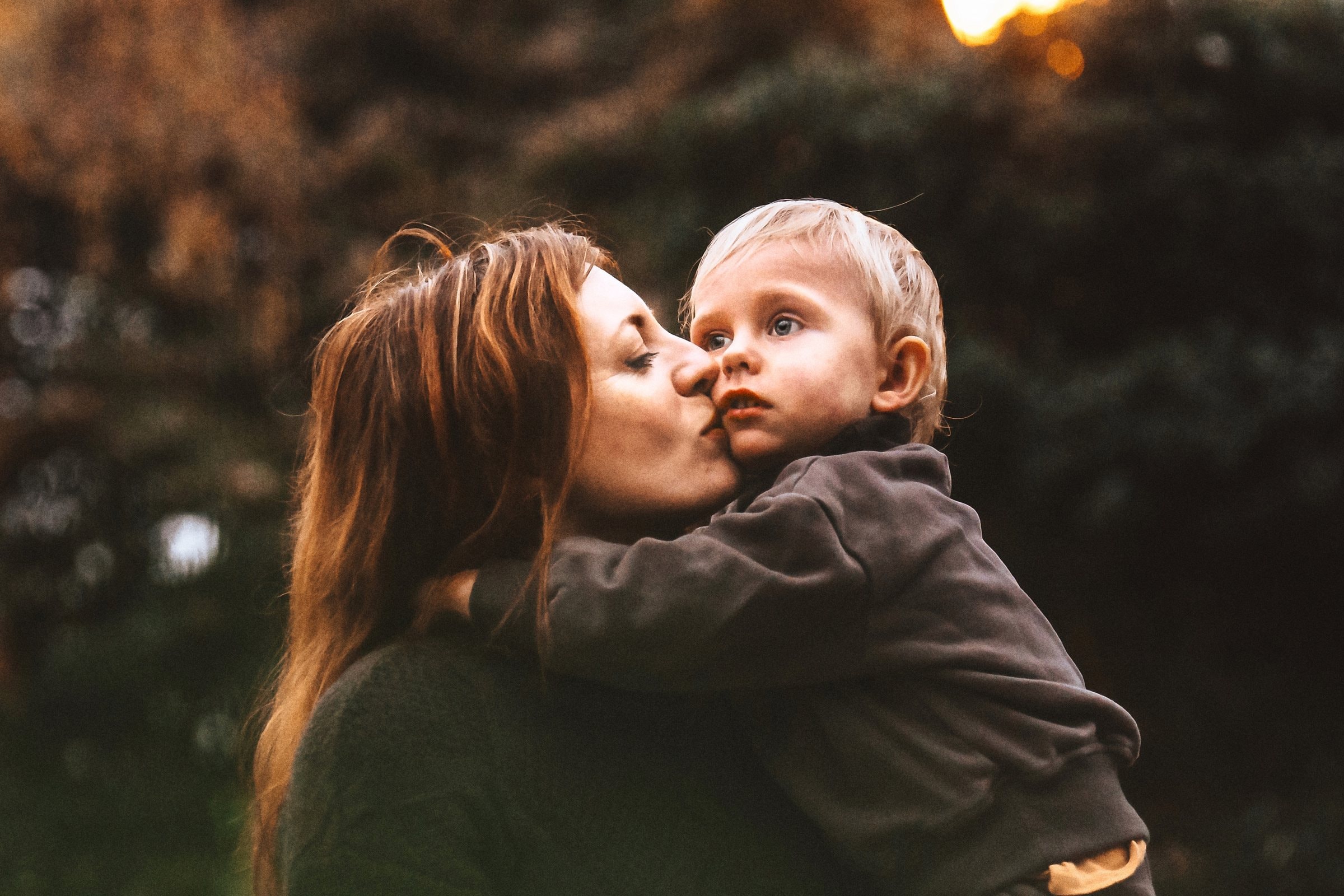 Sandra kissing Edik in warm woodland light