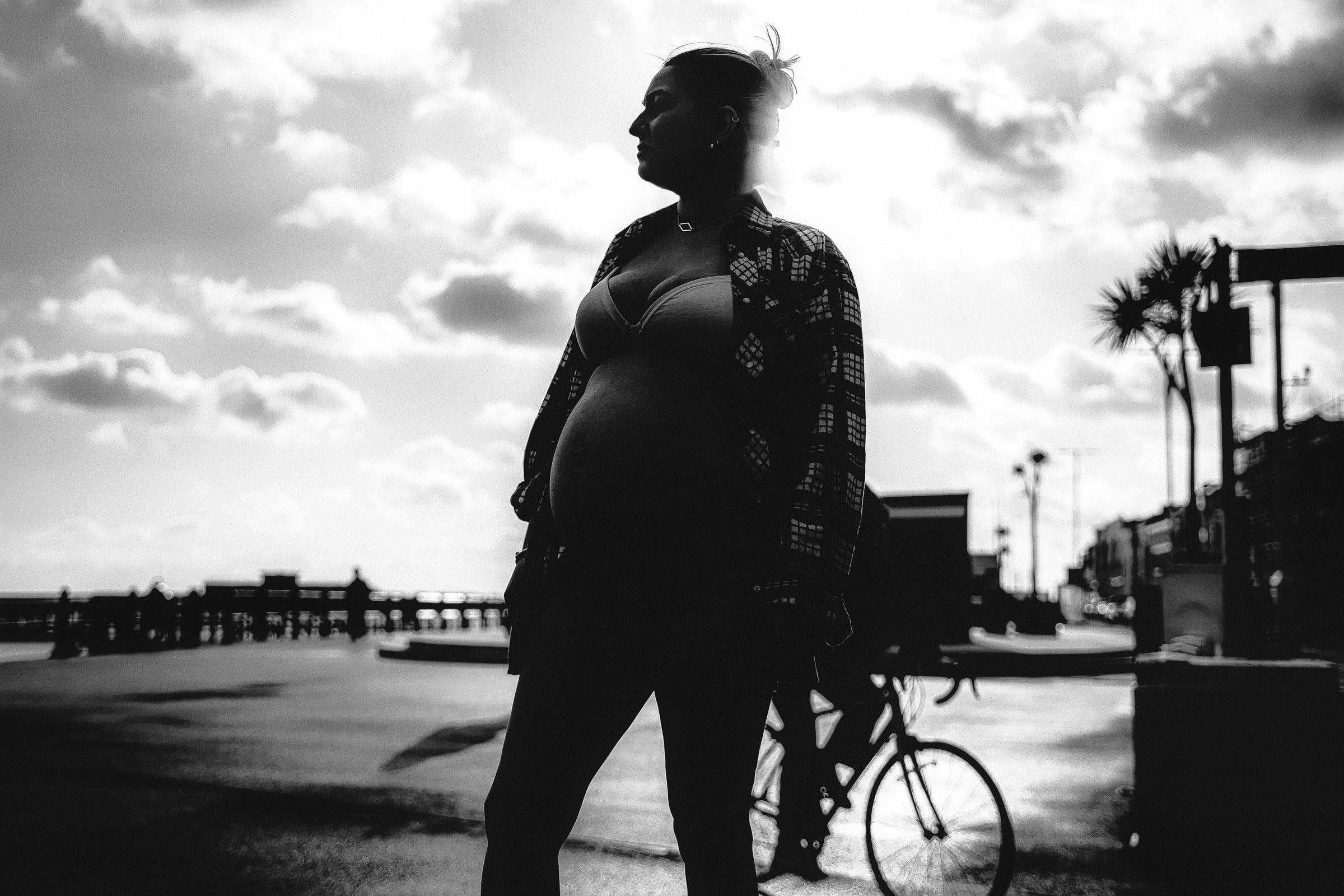Solene standing in silhouette beside a passing cyclist