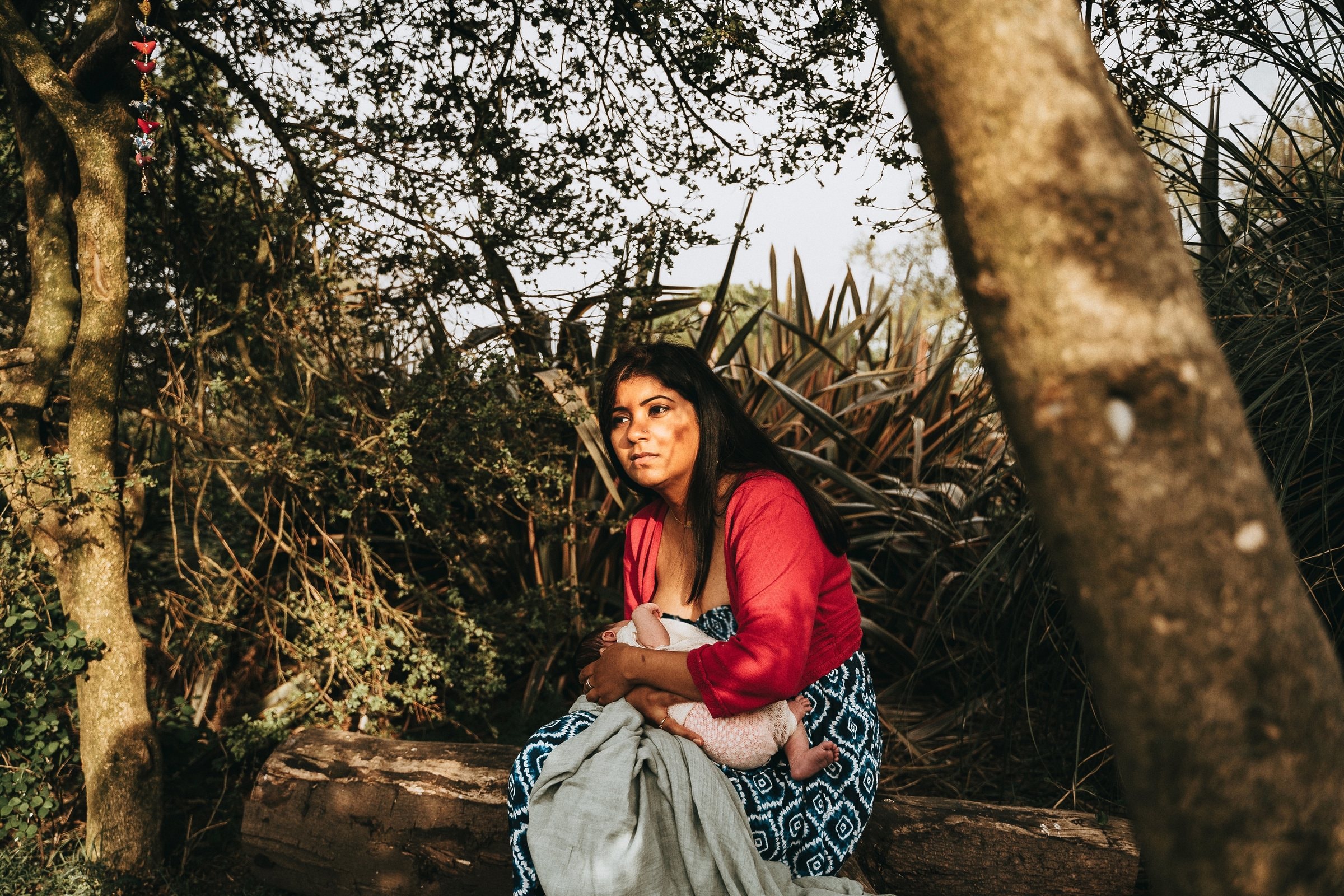 Amaya nursing with her mother in a quiet garden corner