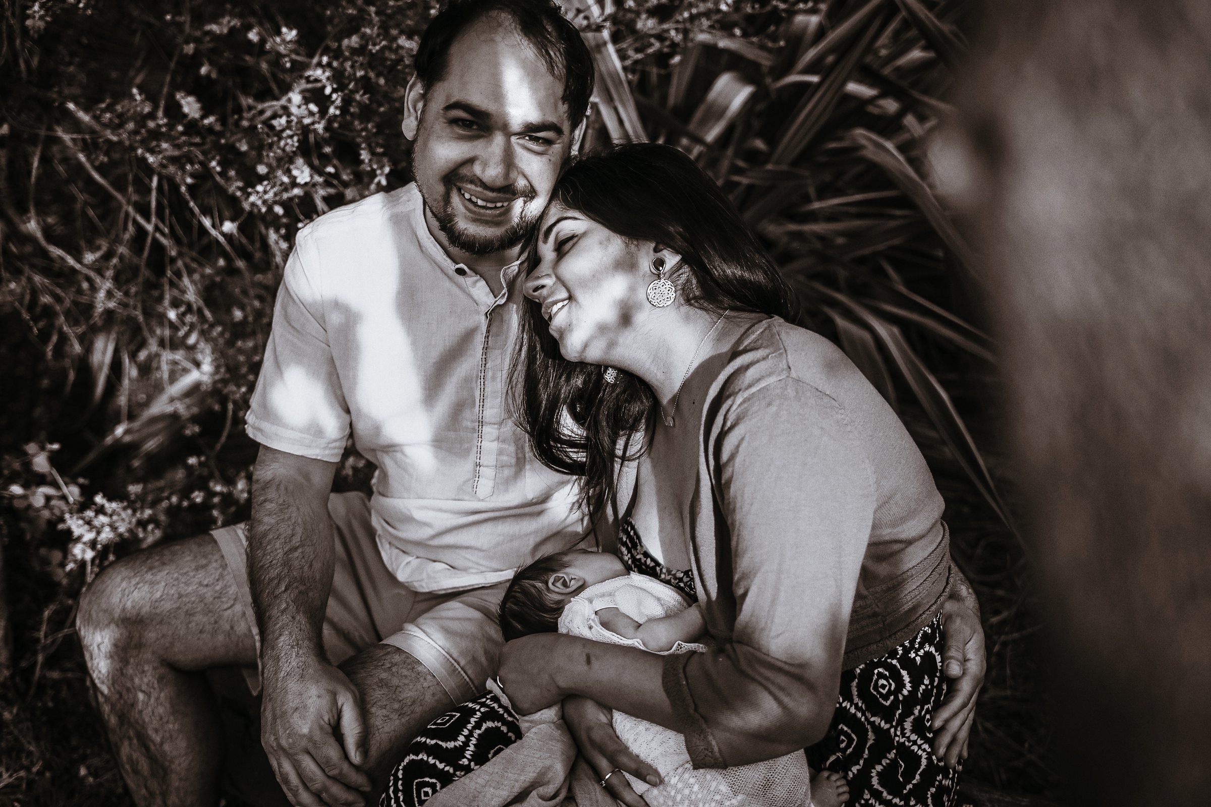 Amaya’s parents smiling together as she rests between them