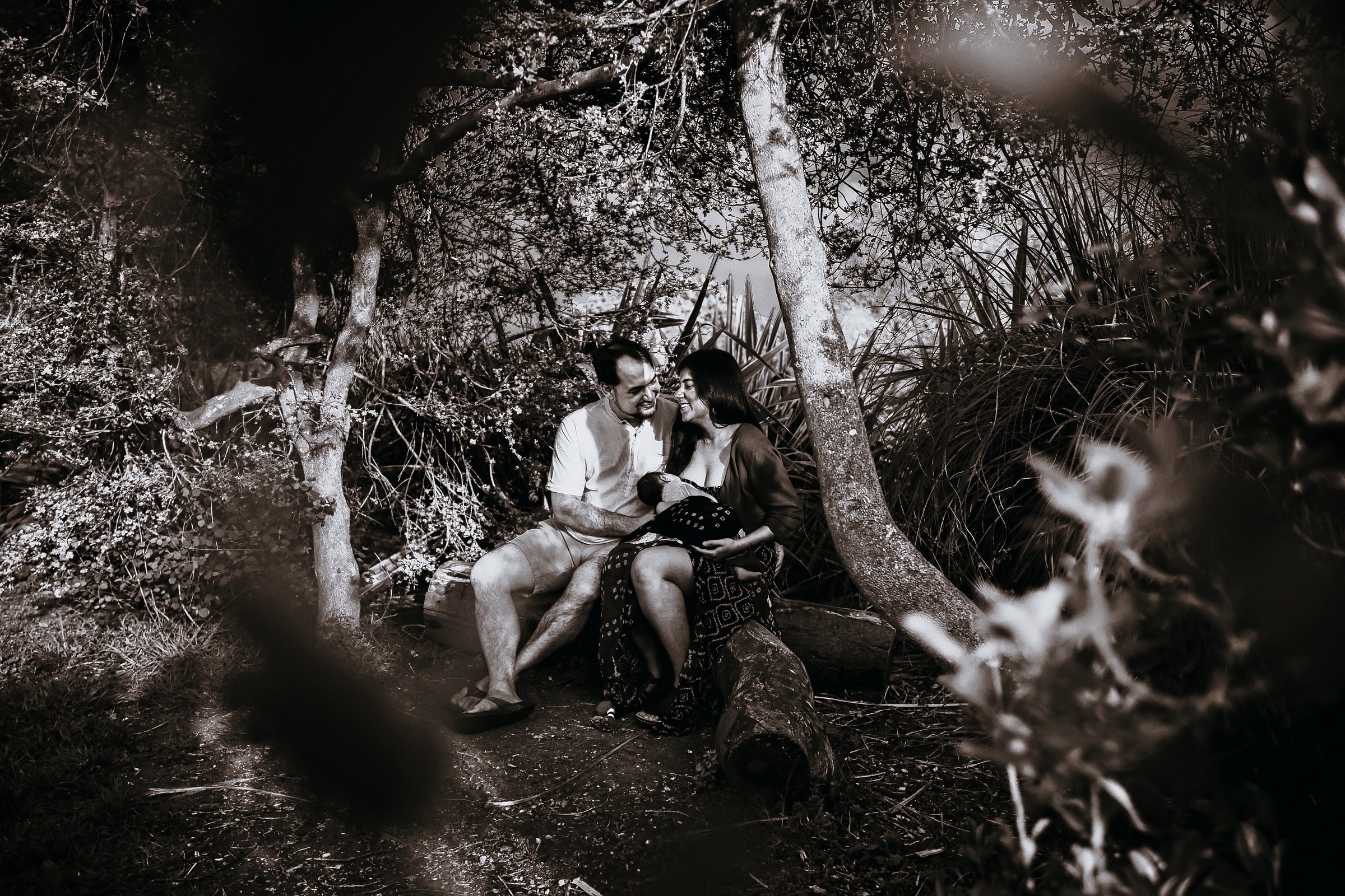 Amaya and her parents seated together among the trees