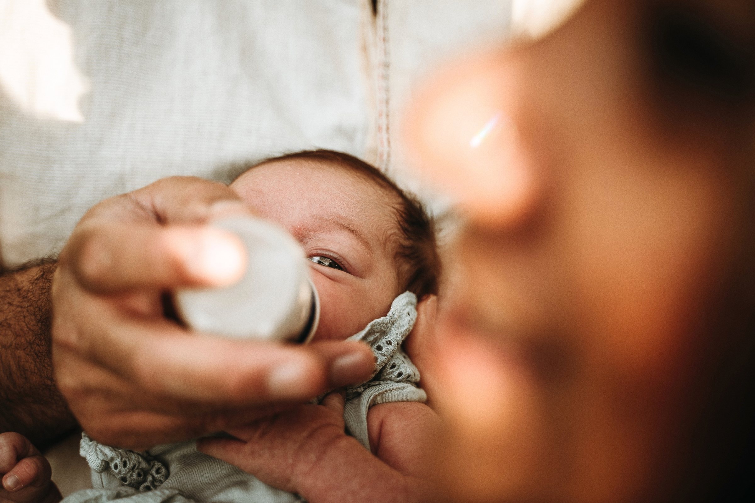 Newborn Amaya drinking milk in a close tender portrait