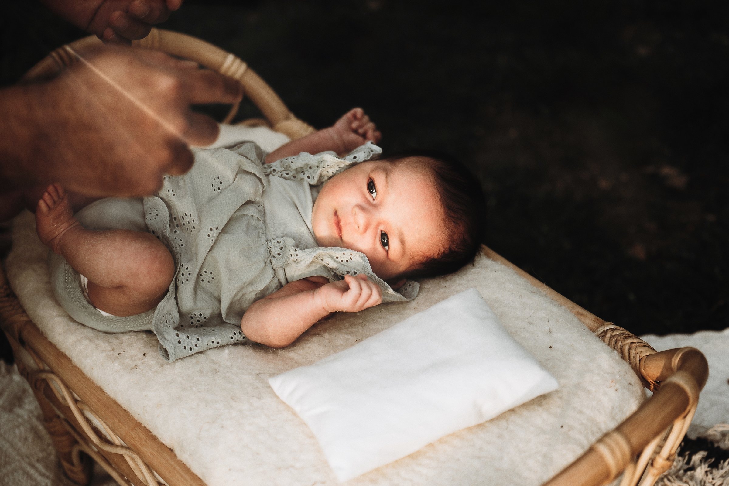Newborn Amaya resting in a woven basket