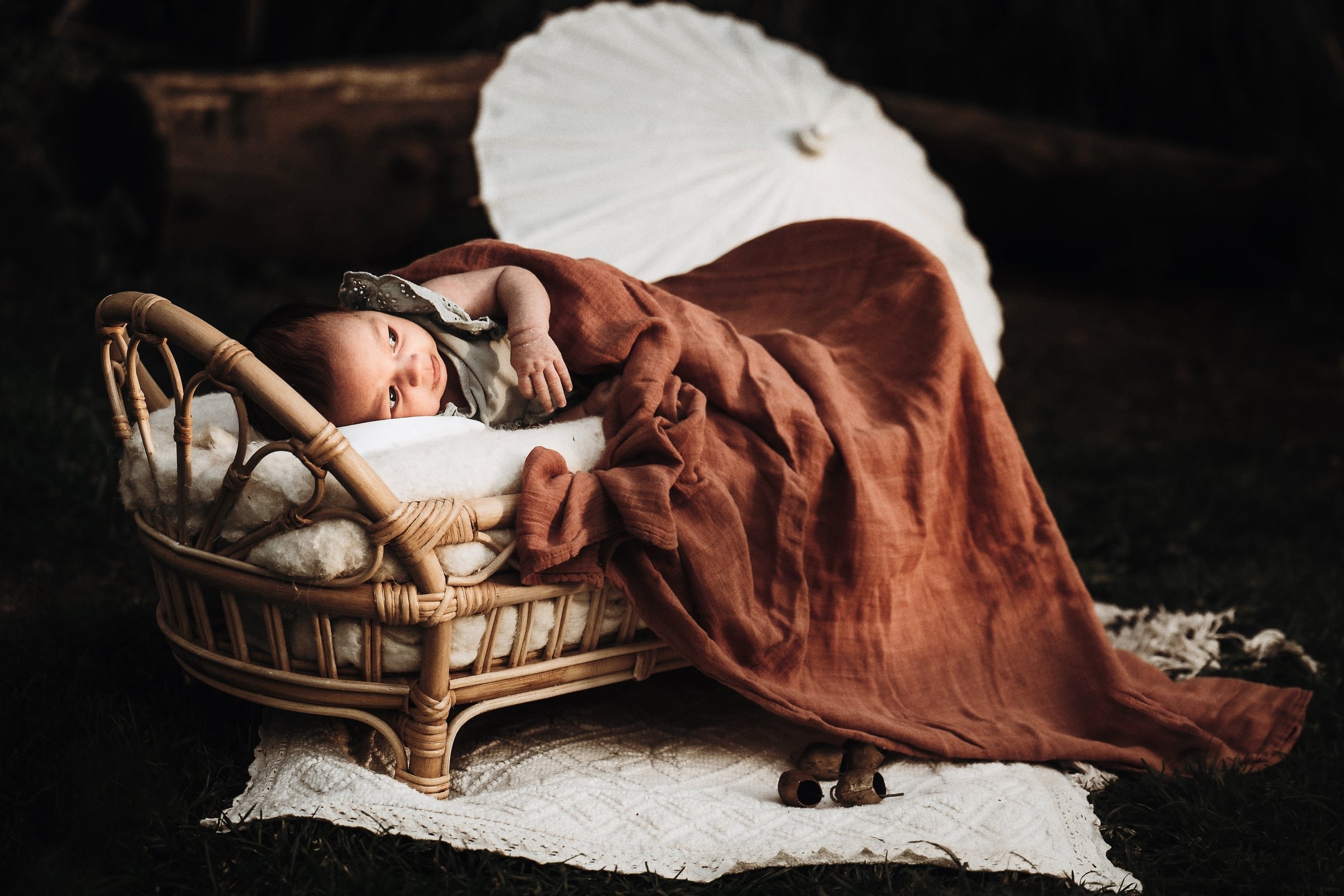 Amaya sleeping beneath a deep rust blanket