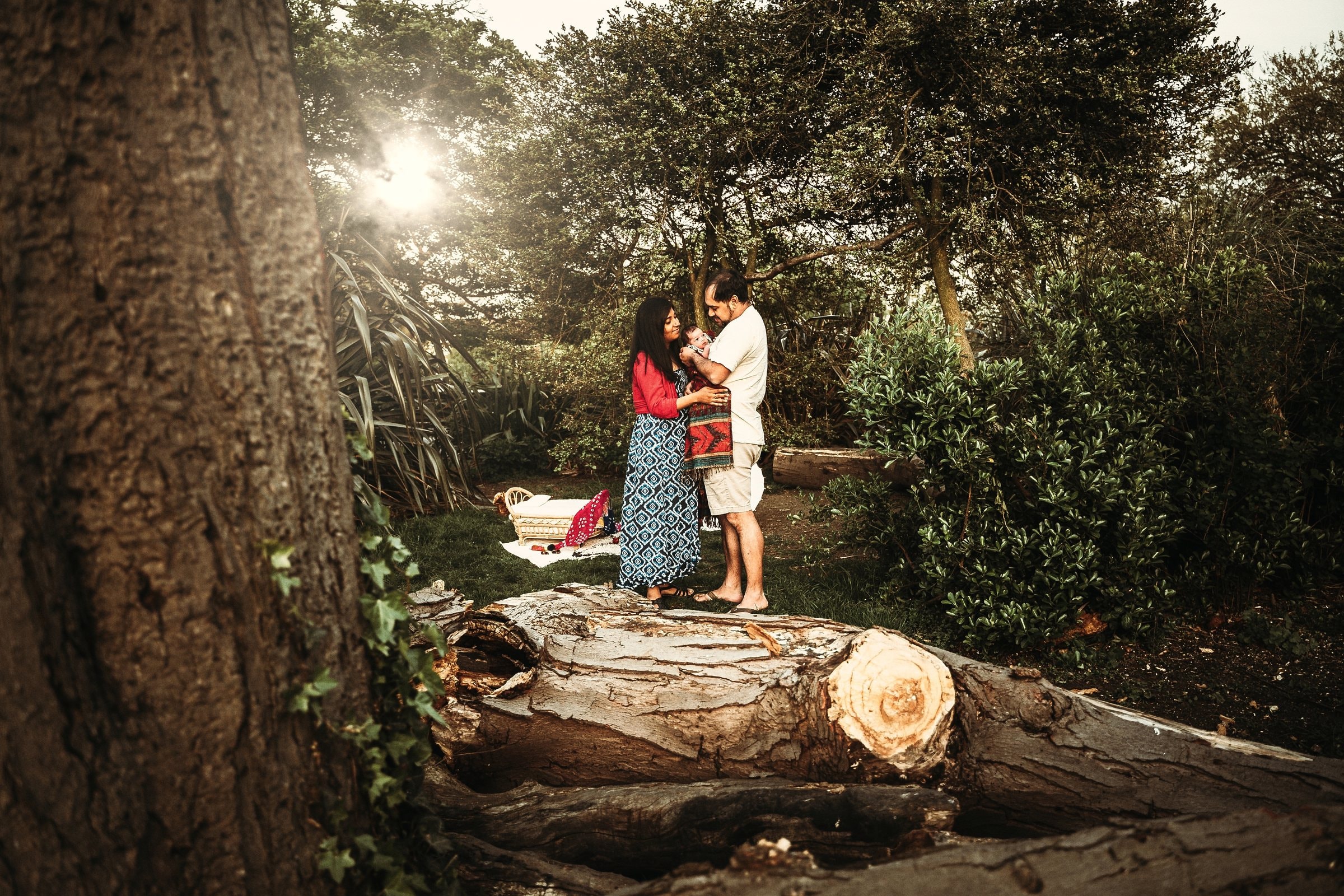 Amaya and her parents standing together beneath the garden trees