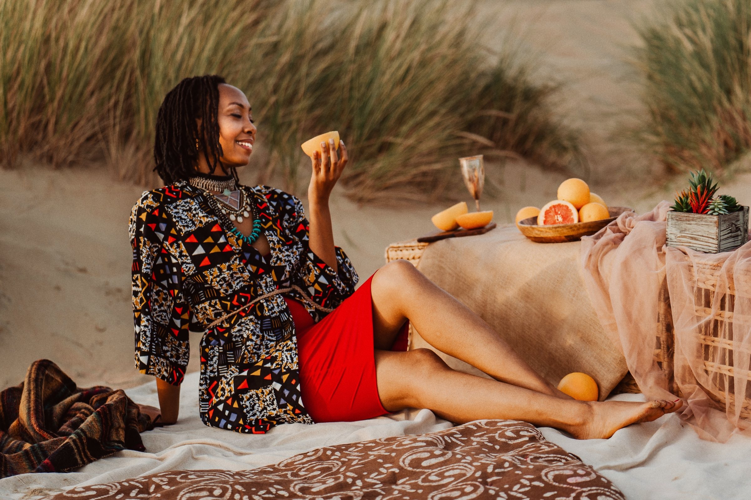 Darla reclining beside a beach picnic