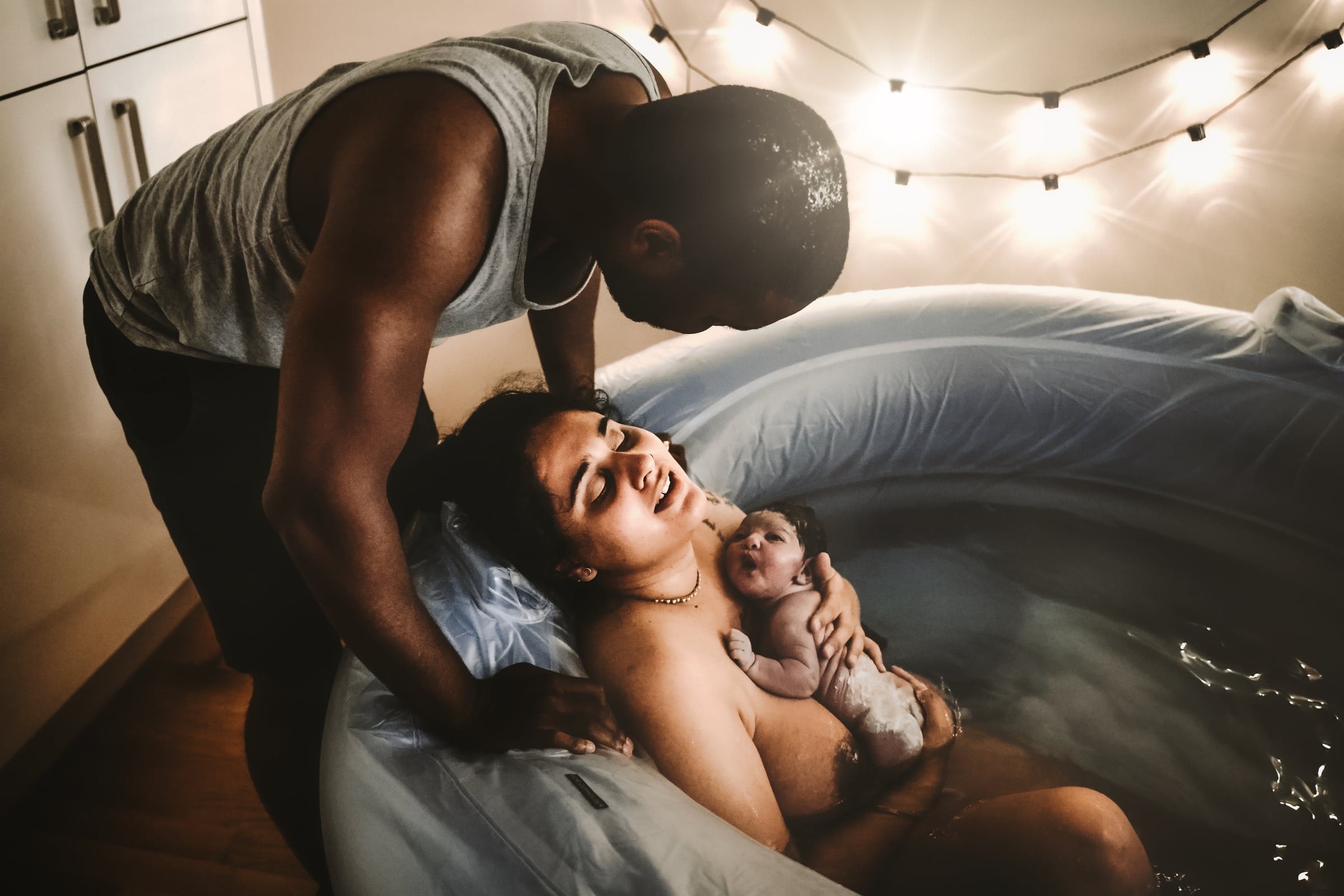 Parents laughing together with their newborn