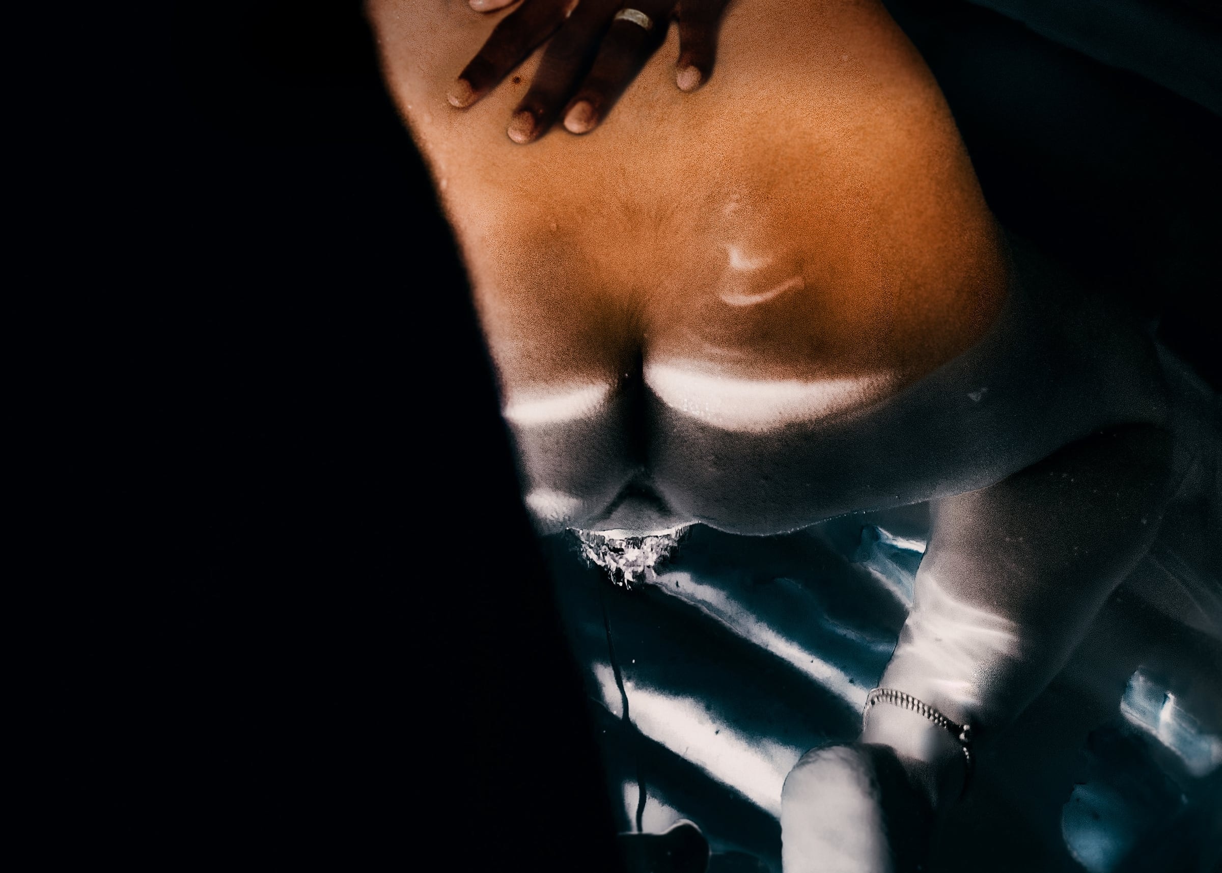 Hands and body reflected in rippling water