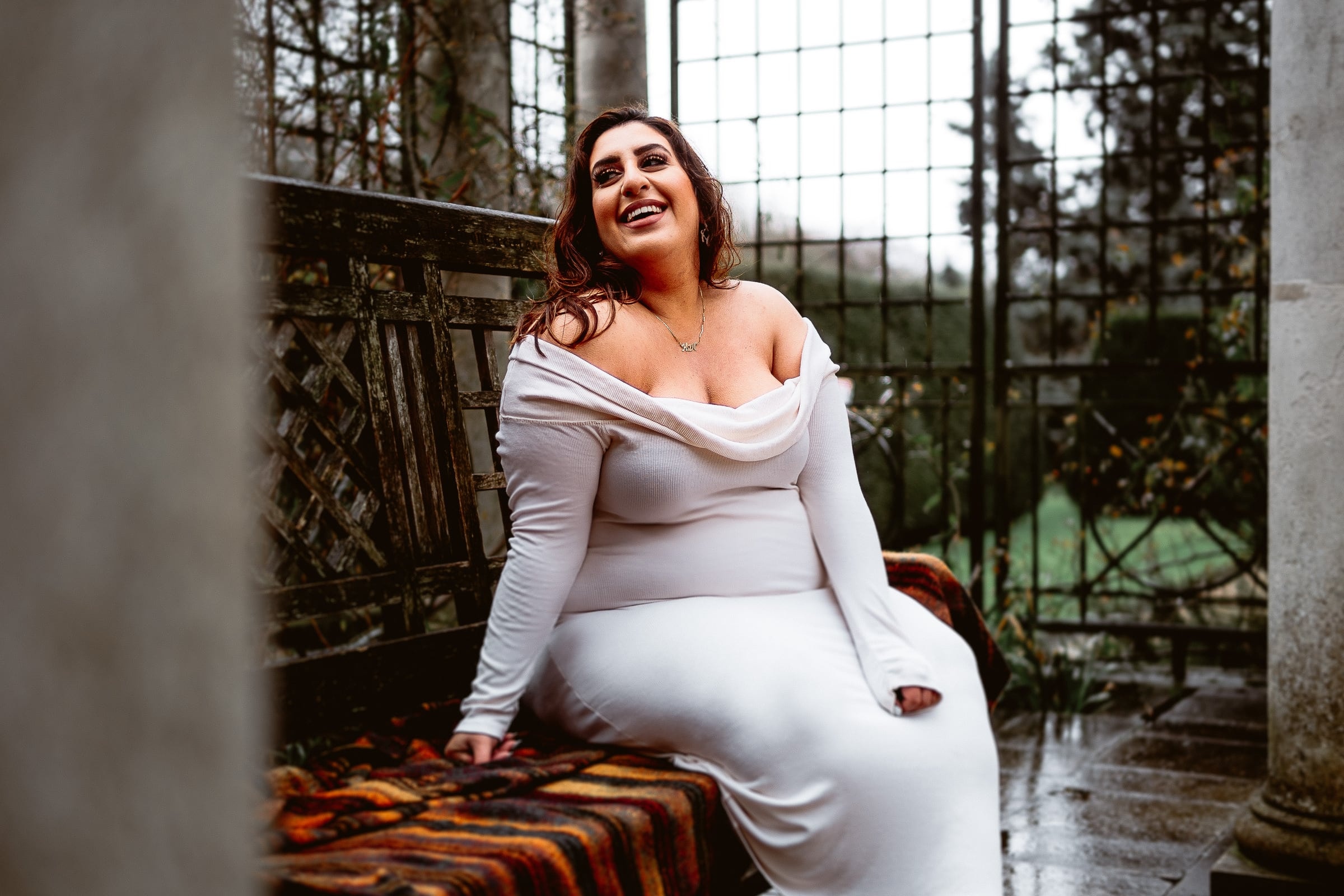 Pregnant woman in white seated in a garden
