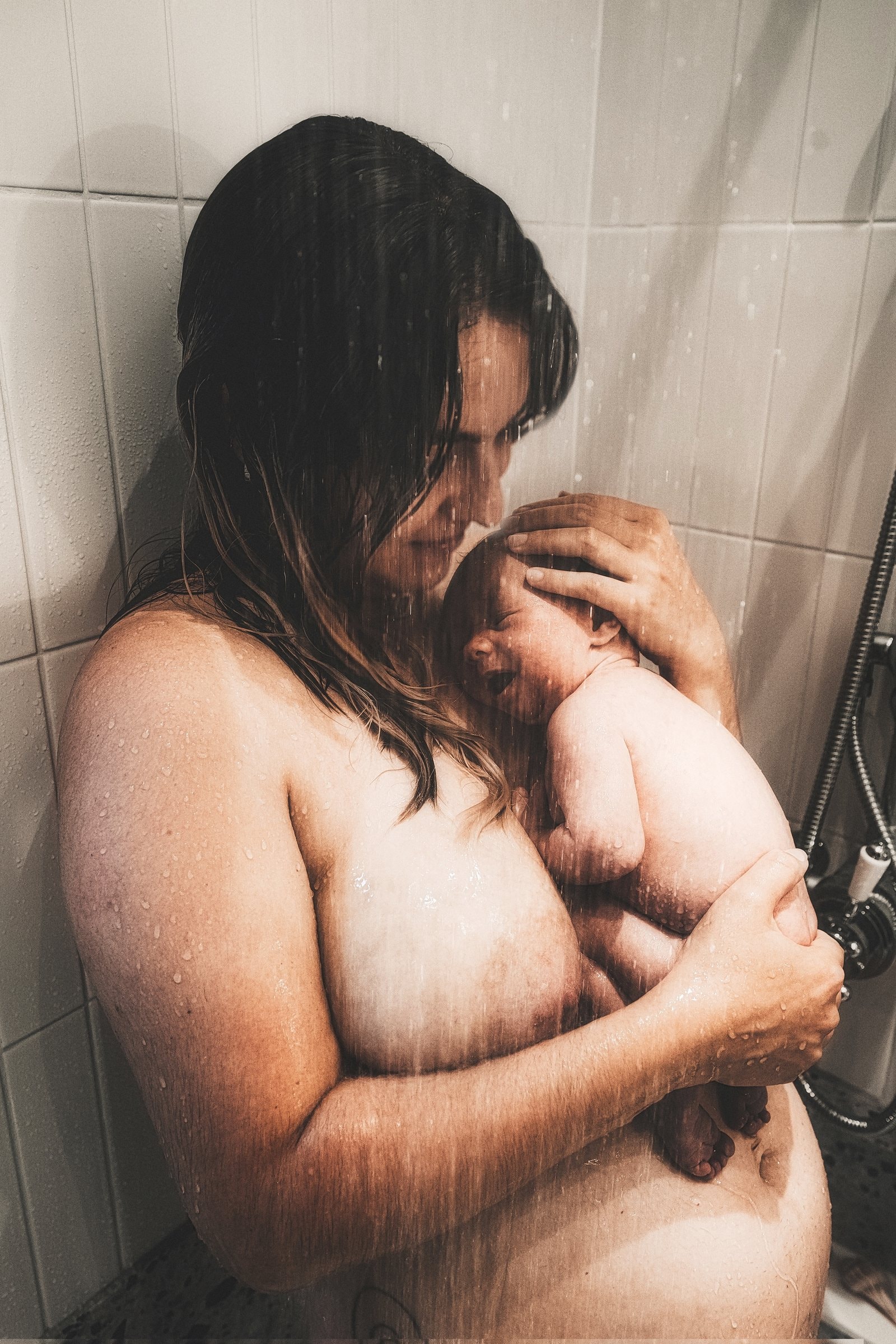 Solene holding Juno close in a quiet bathroom portrait