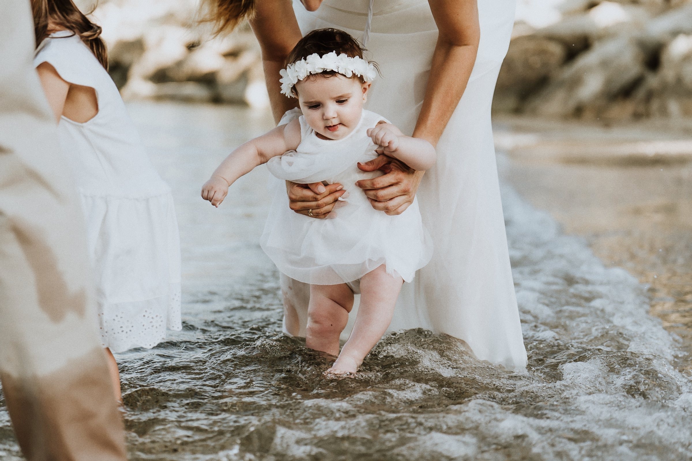 A baby taking careful steps at the waterline