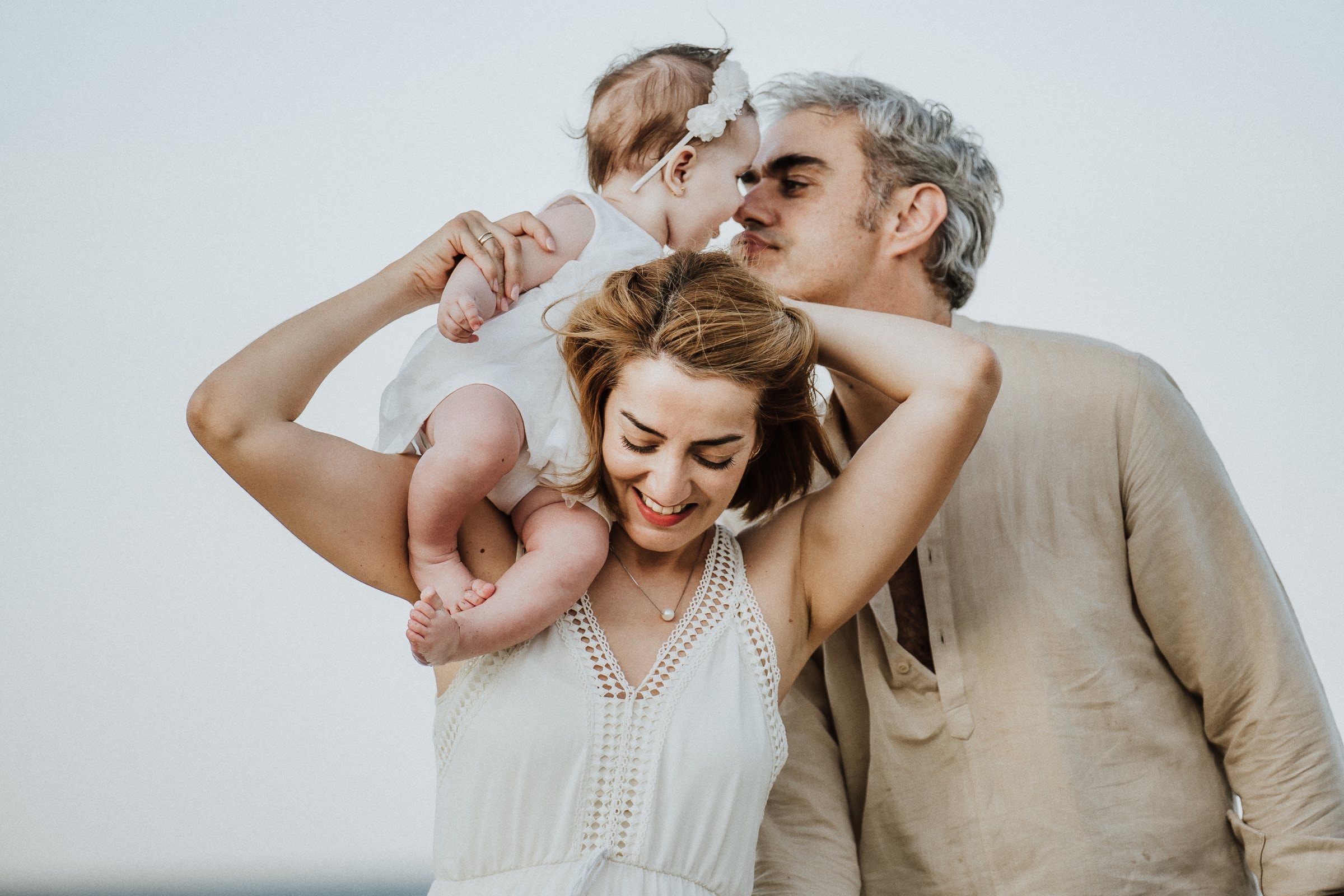 Tasha lifting her baby while her family leans close