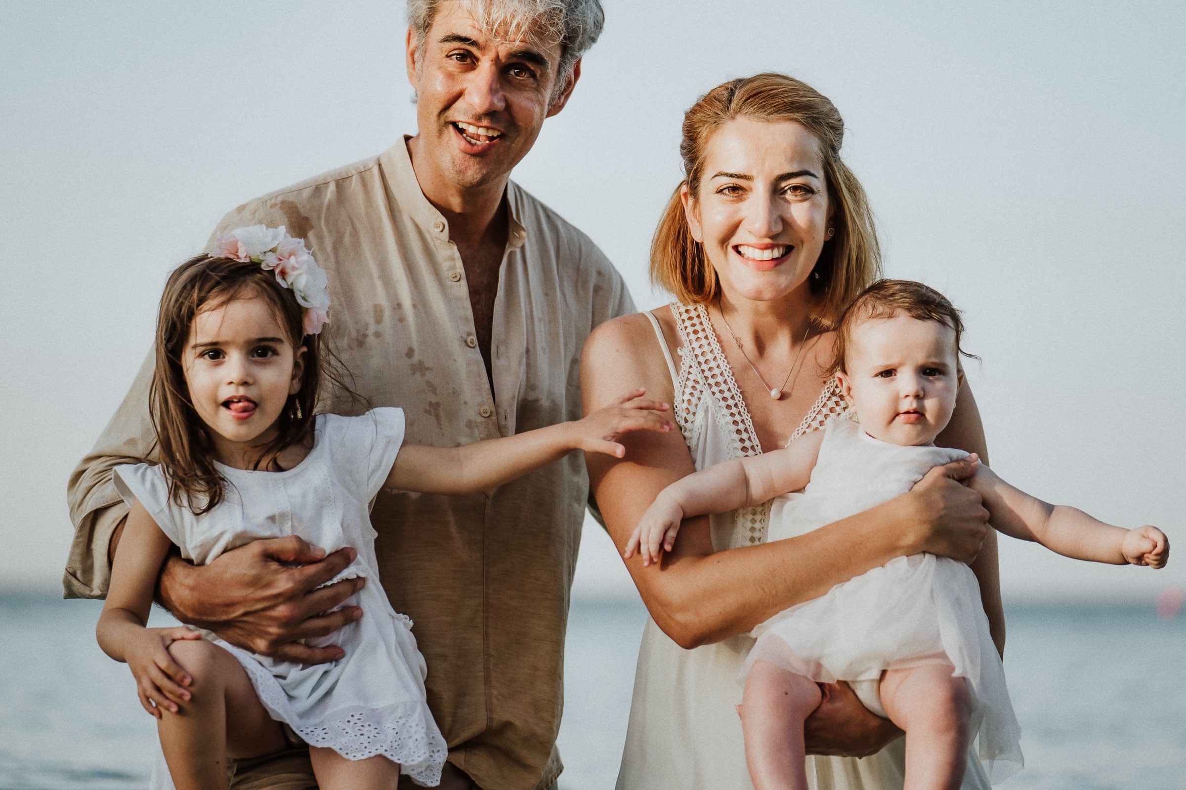 The family standing together with their children by the water