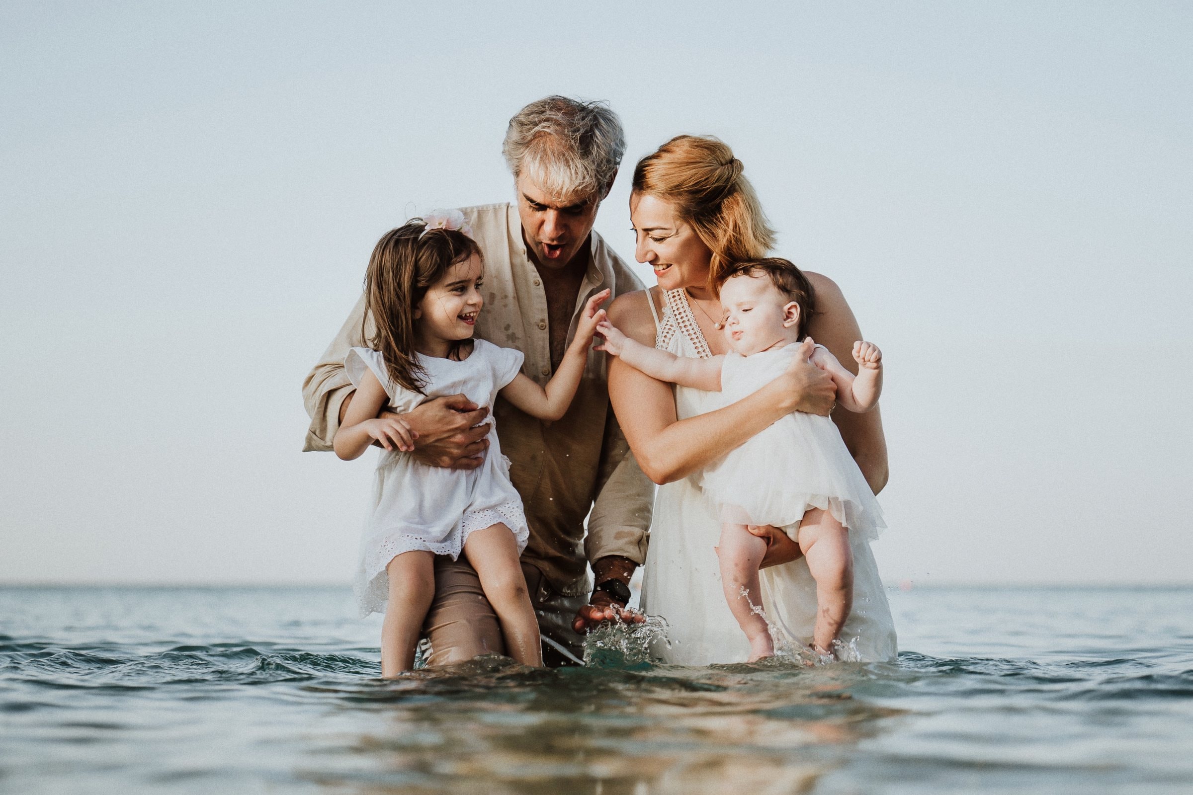 The family kneeling together in the shallow sea