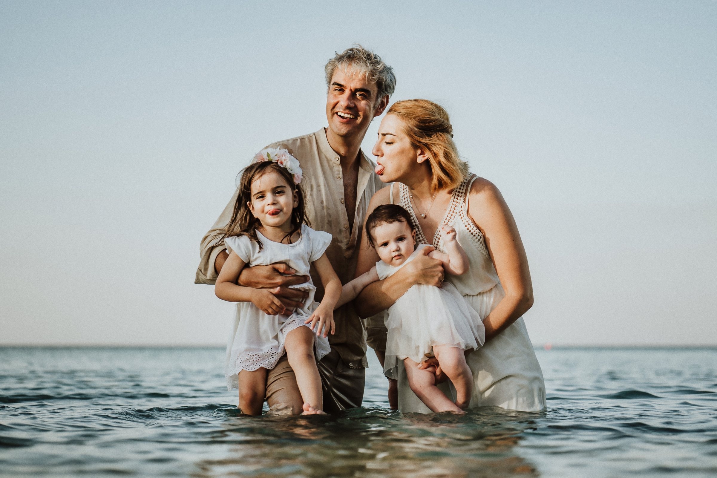 Tasha and her family smiling together against the pale horizon