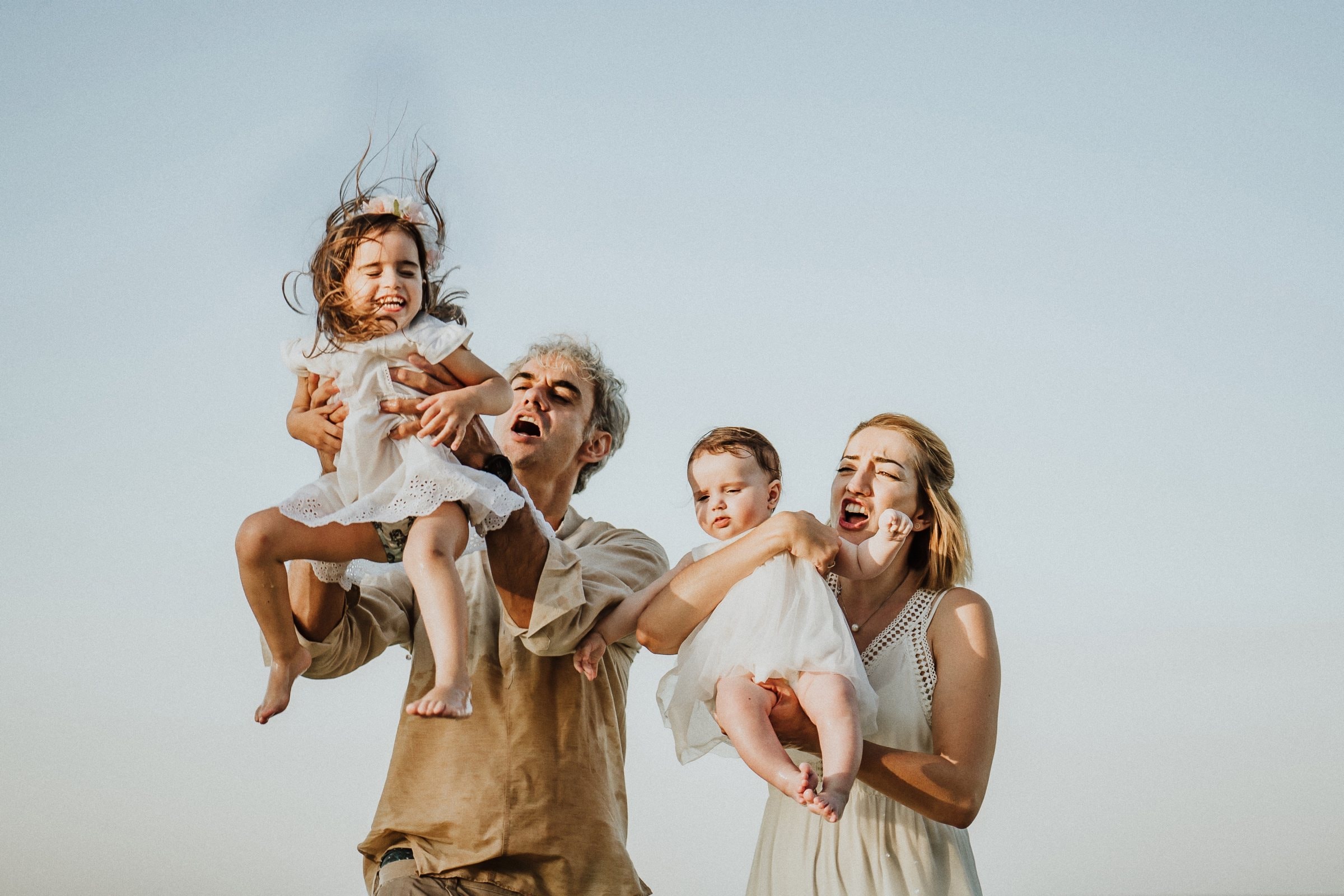 The family lifting their children into the evening light