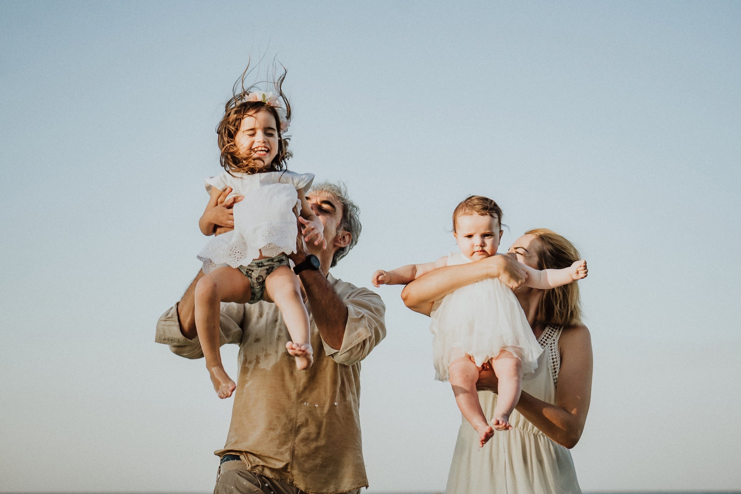 The family throwing their children joyfully into the air