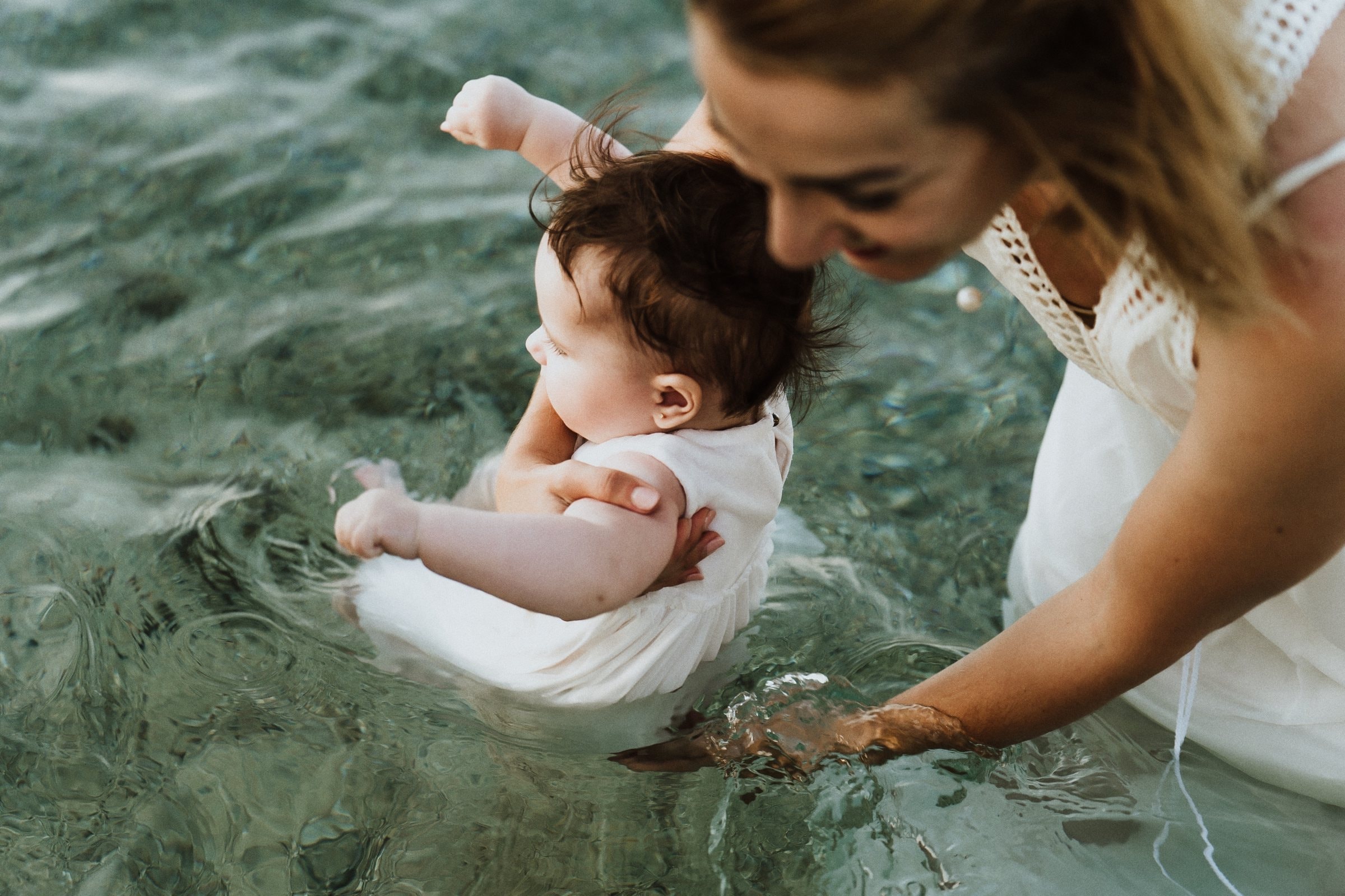 Tasha guiding her baby through the clear sea