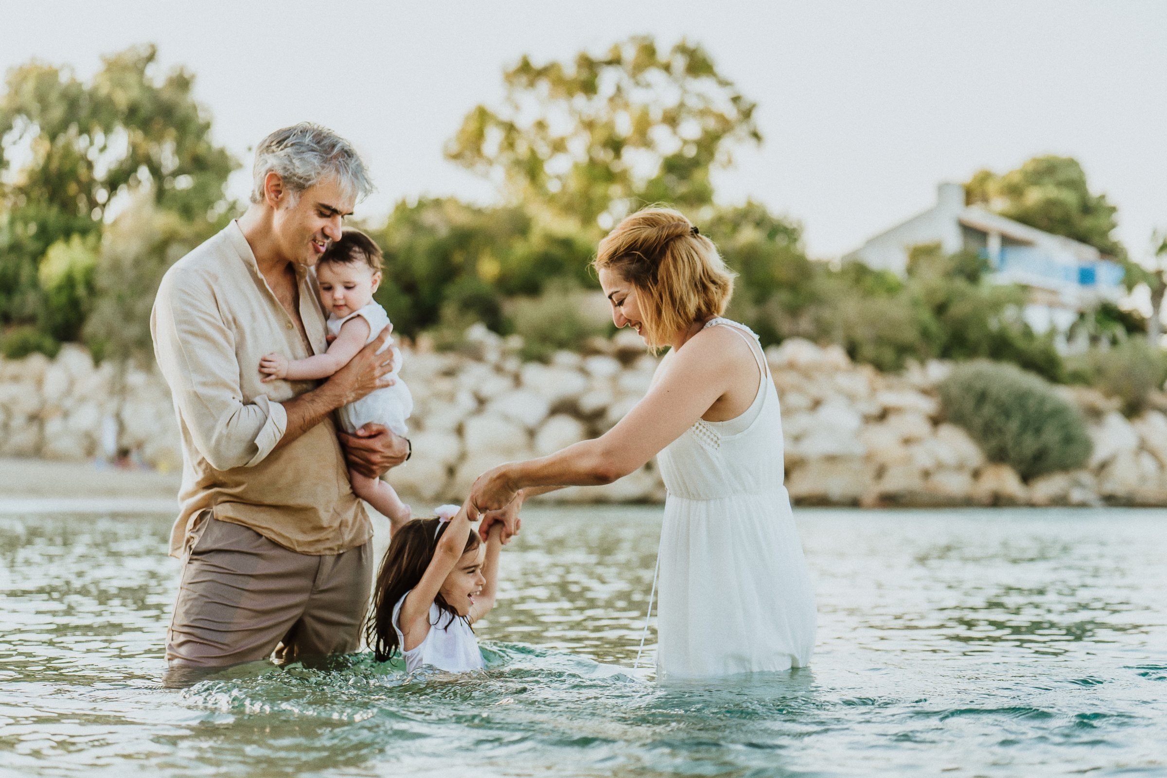 Tasha and her partner steadying their children in the water