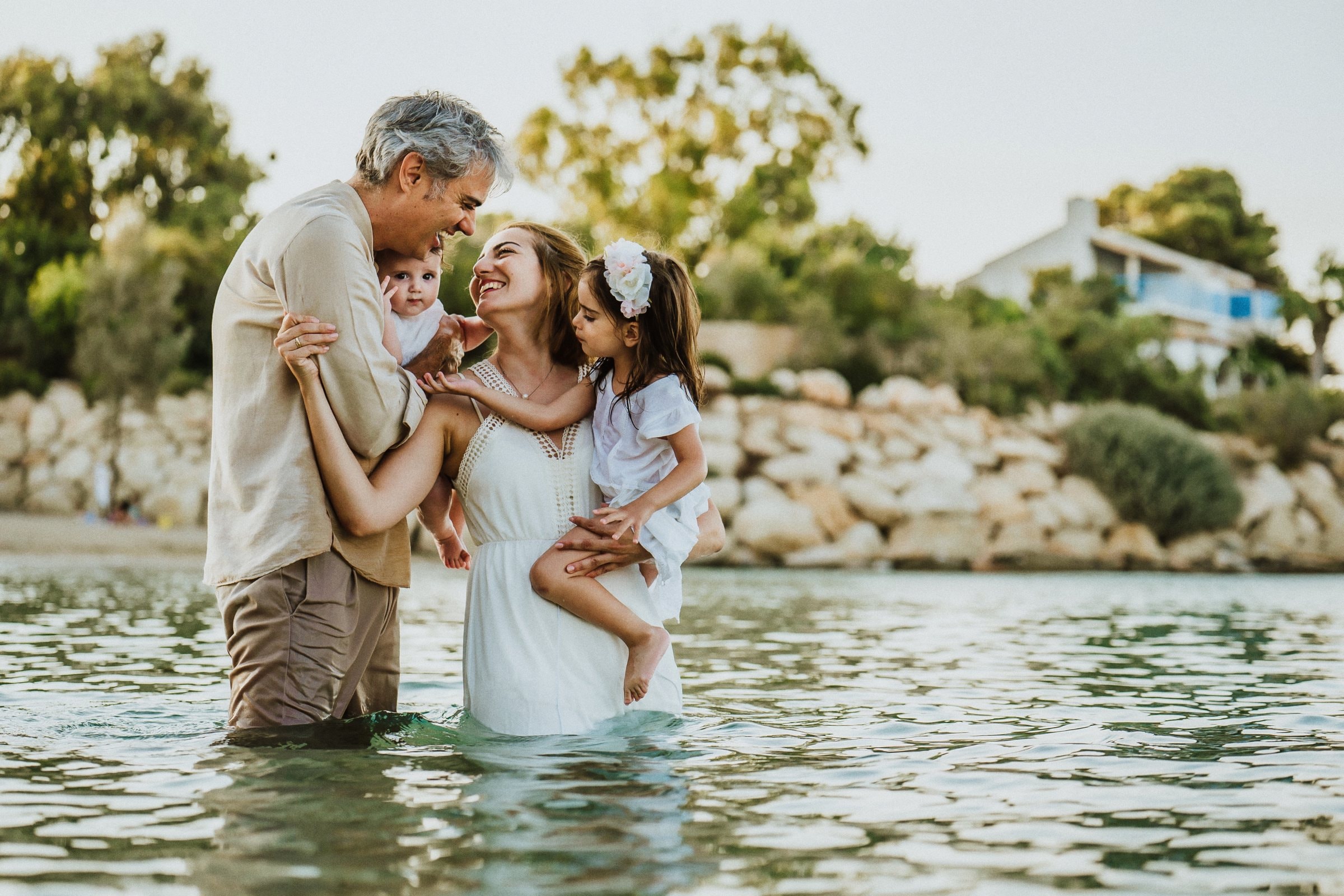A father kissing his daughter while holding the baby