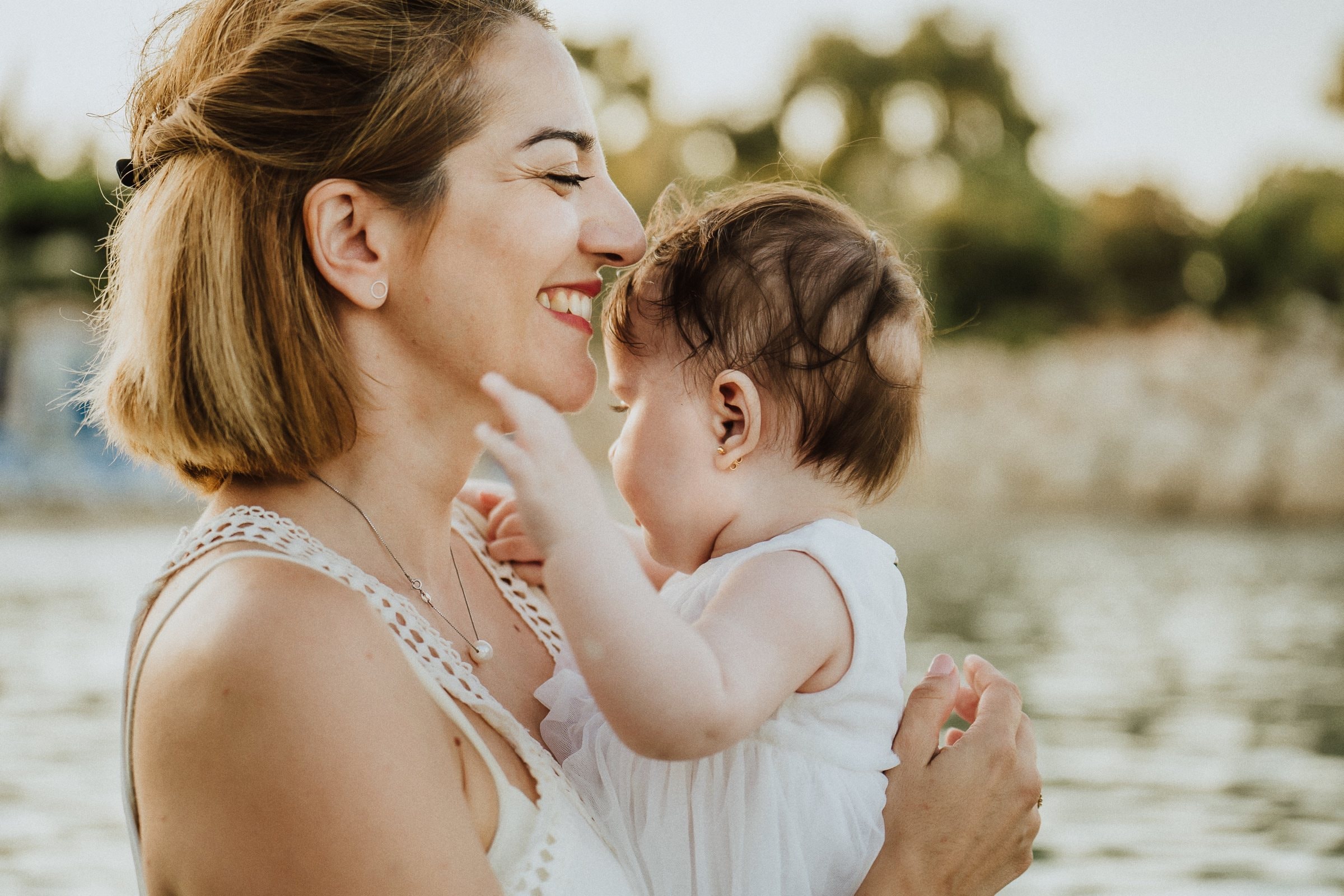 A mother and daughter touching foreheads in the golden light