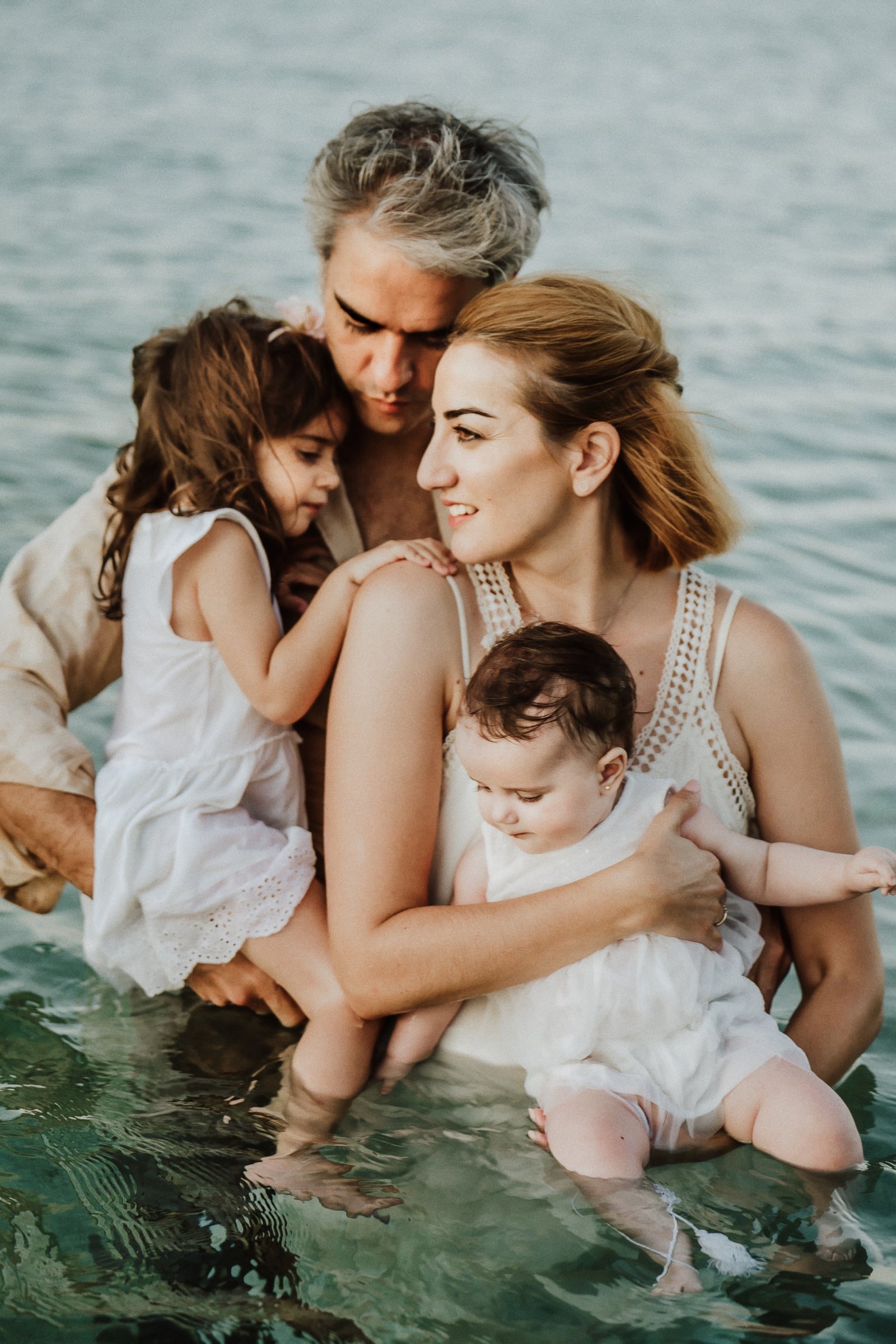 Tasha holding both children while her partner embraces them