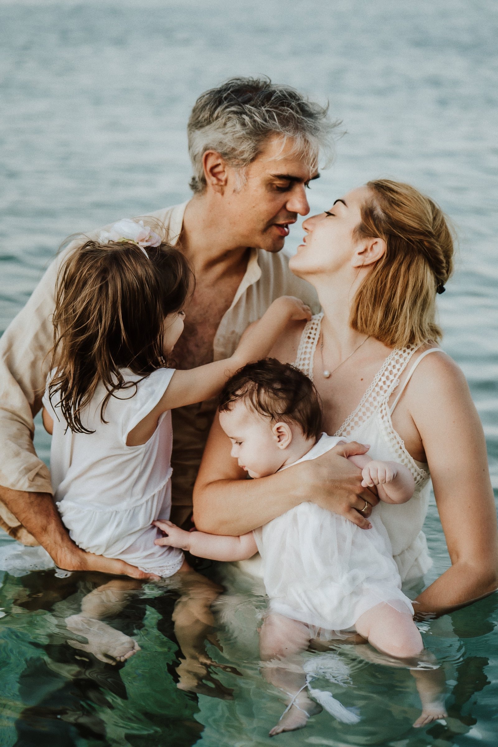 Tasha and her partner kissing above their children