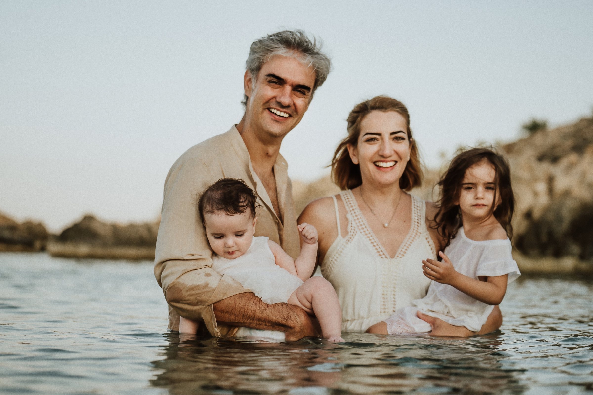 Tasha and her family standing together in the calm sea