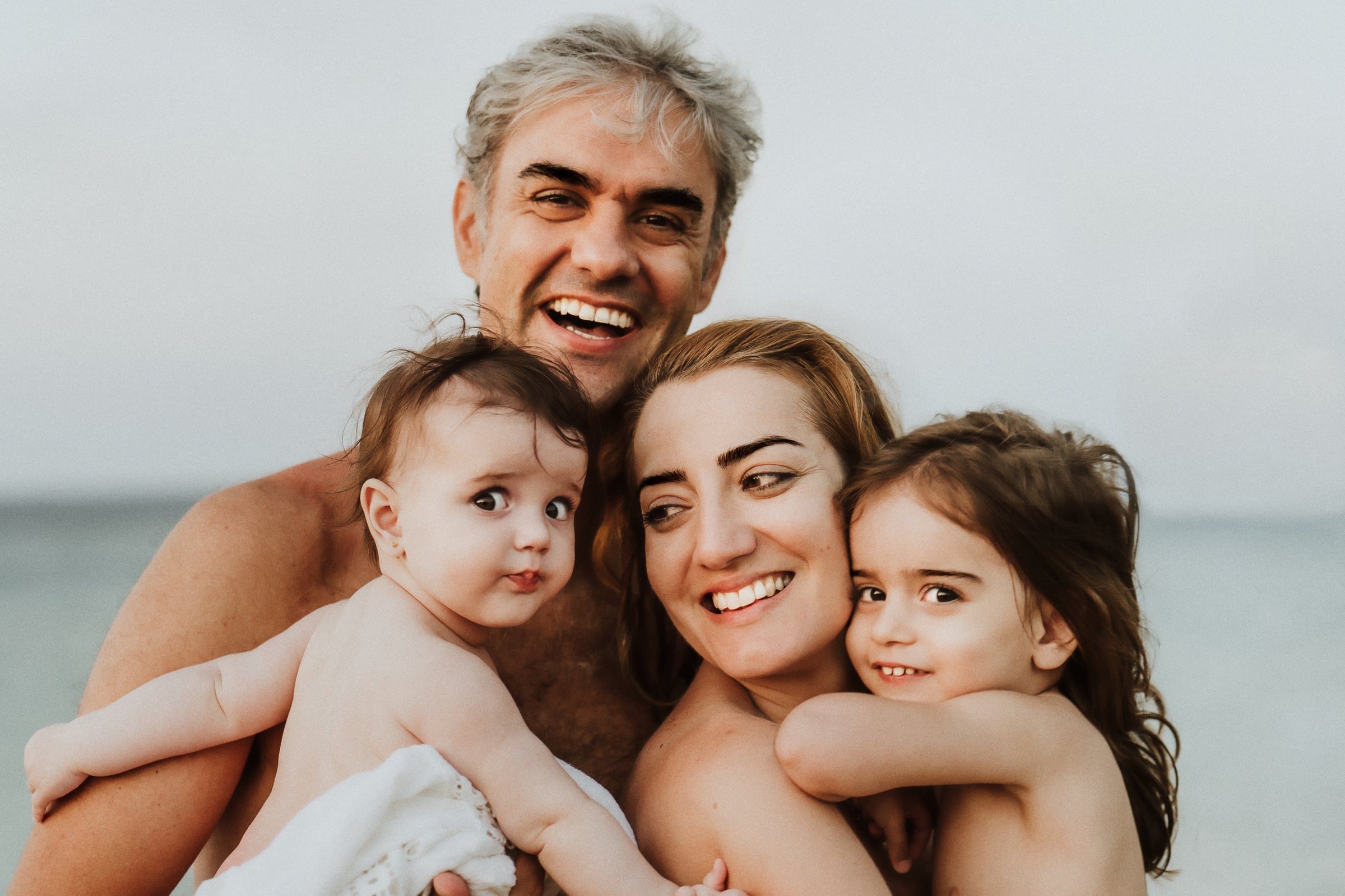 Tasha and her family smiling in a close beach portrait
