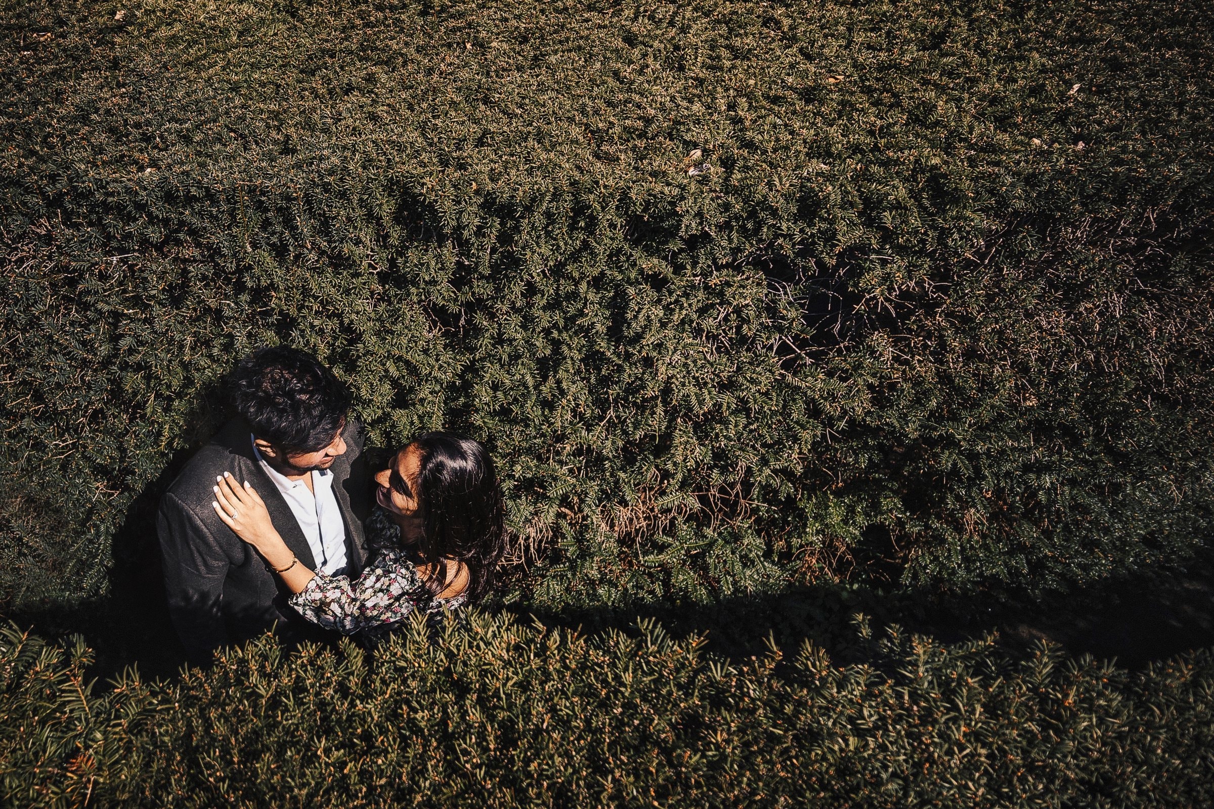 A newly married couple lying together in a field of green